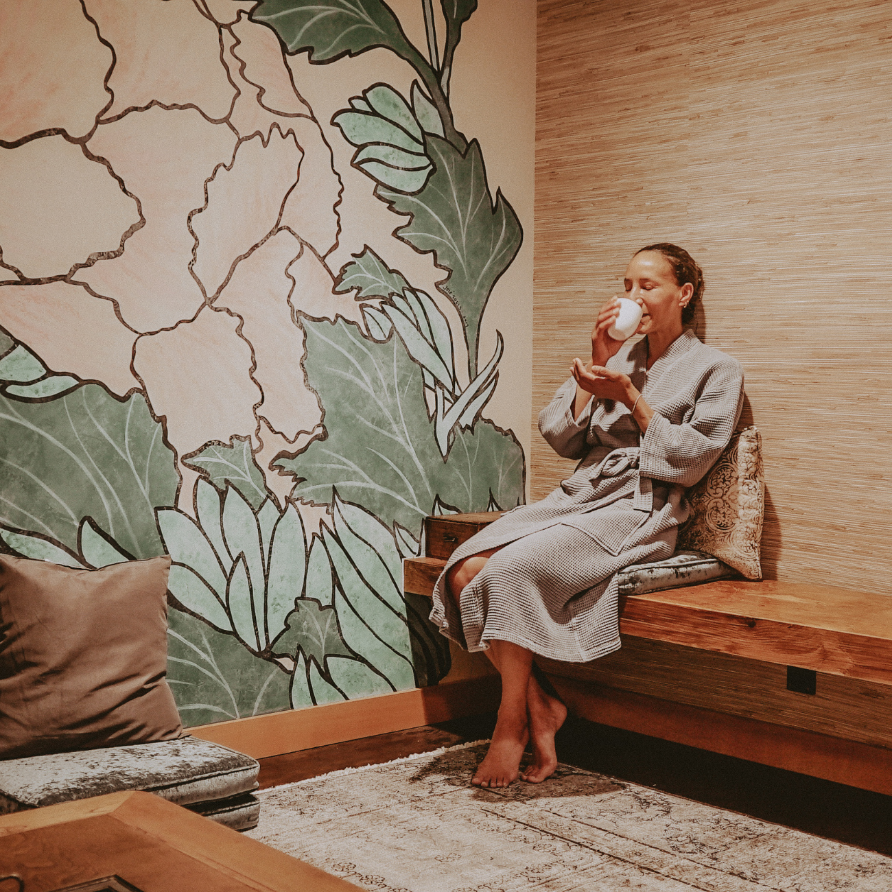 Happy client enjoying a cup of medicinal tea in our serene tea room before treatment