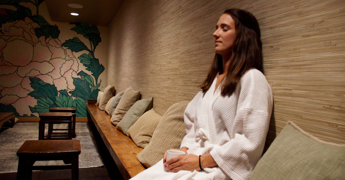 Woman relaxing peacefully in the serene tea room at Root Whole Body in northwest Portland.